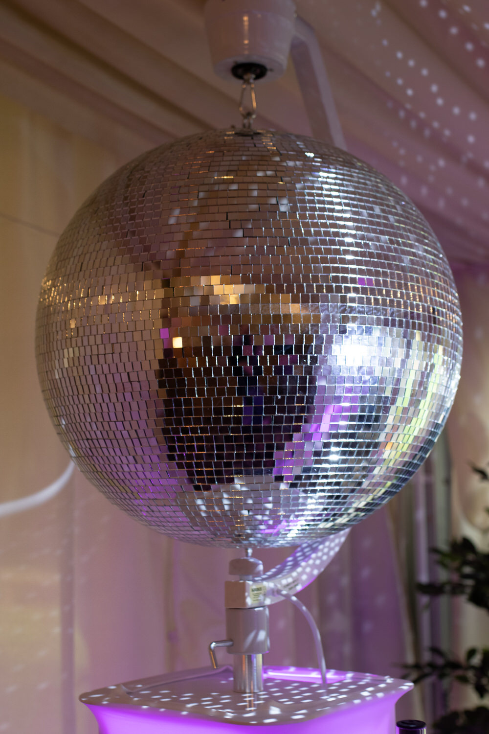 Giant mirror ball suspended above a purple-lit poseur table at Hogarths Stone Manor, Worcestershire — mirror ball hire included in The Spectacle and Diamond packages by Blue Diamond Entertainment