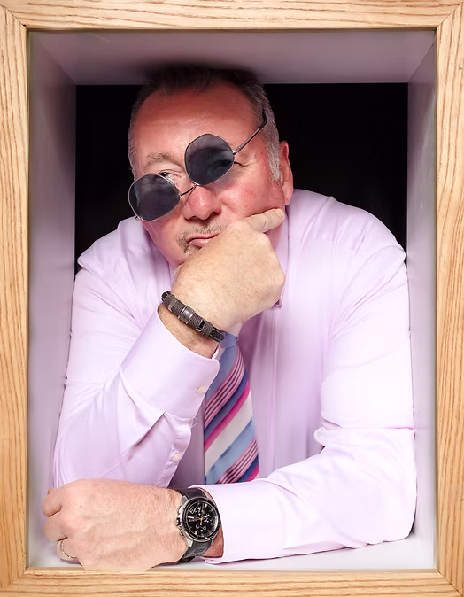 Wedding guest in pink shirt with sunglasses leaning on hand inside a wooden box frame — Wedding Box Photo Booth portrait
